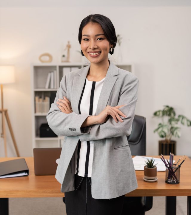 Portrait of young beautiful business asian woman in the office. Crossed arms